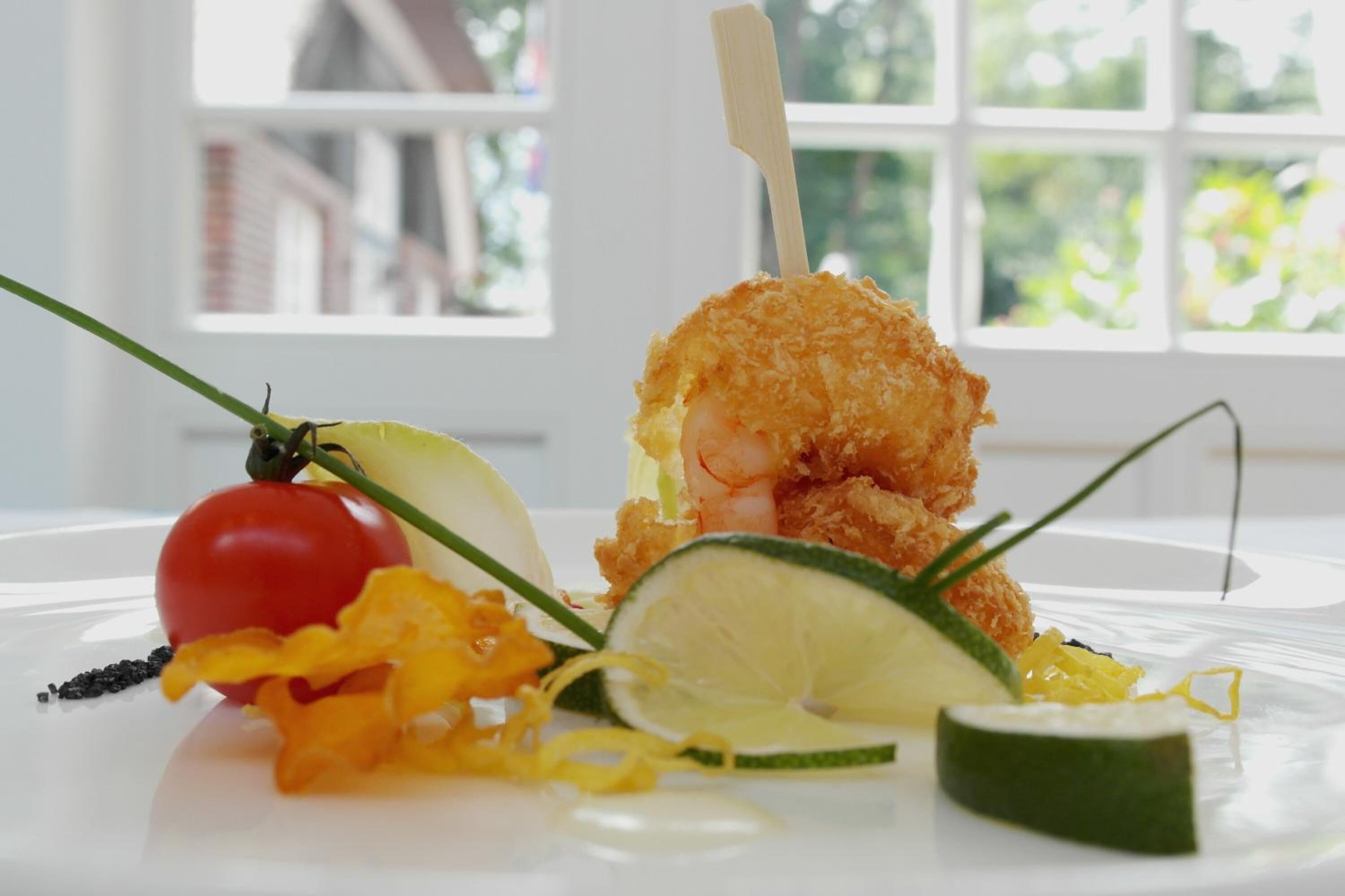 A seafood dish with a shrimp on a stick, garnished with lemon and herbs, on a white plate.