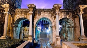 An ancient stone archway with columns, leading to a staircase. - Kont Pansiyon (Antalya)