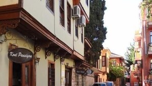 A narrow street with buildings on either side, featuring a restaurant named 'Kout Pansiyon' with outdoor seating. - Kont Pansiyon (Antalya)
