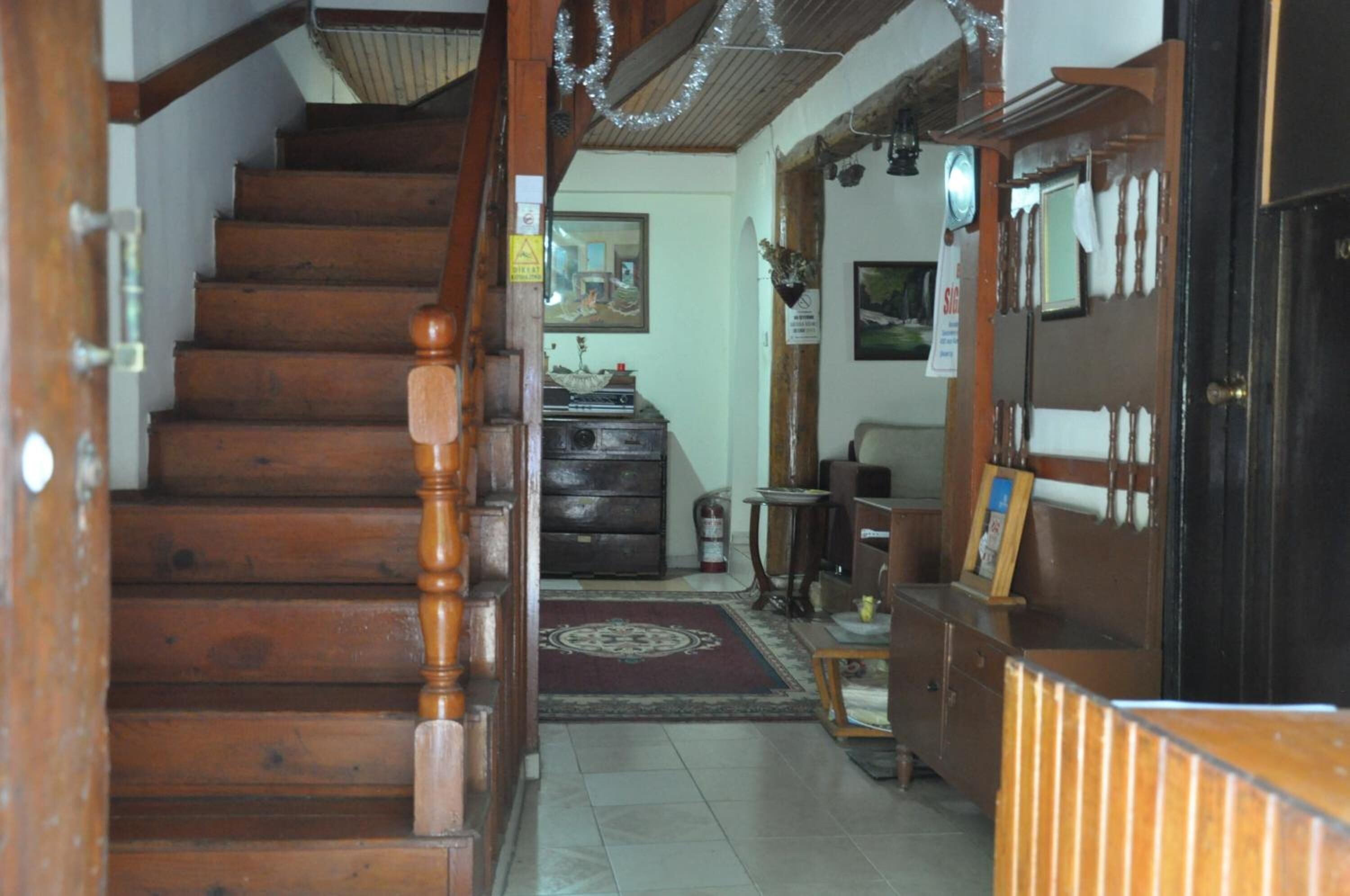 A wooden staircase leading to a room with a desk, chair, and a small rug.