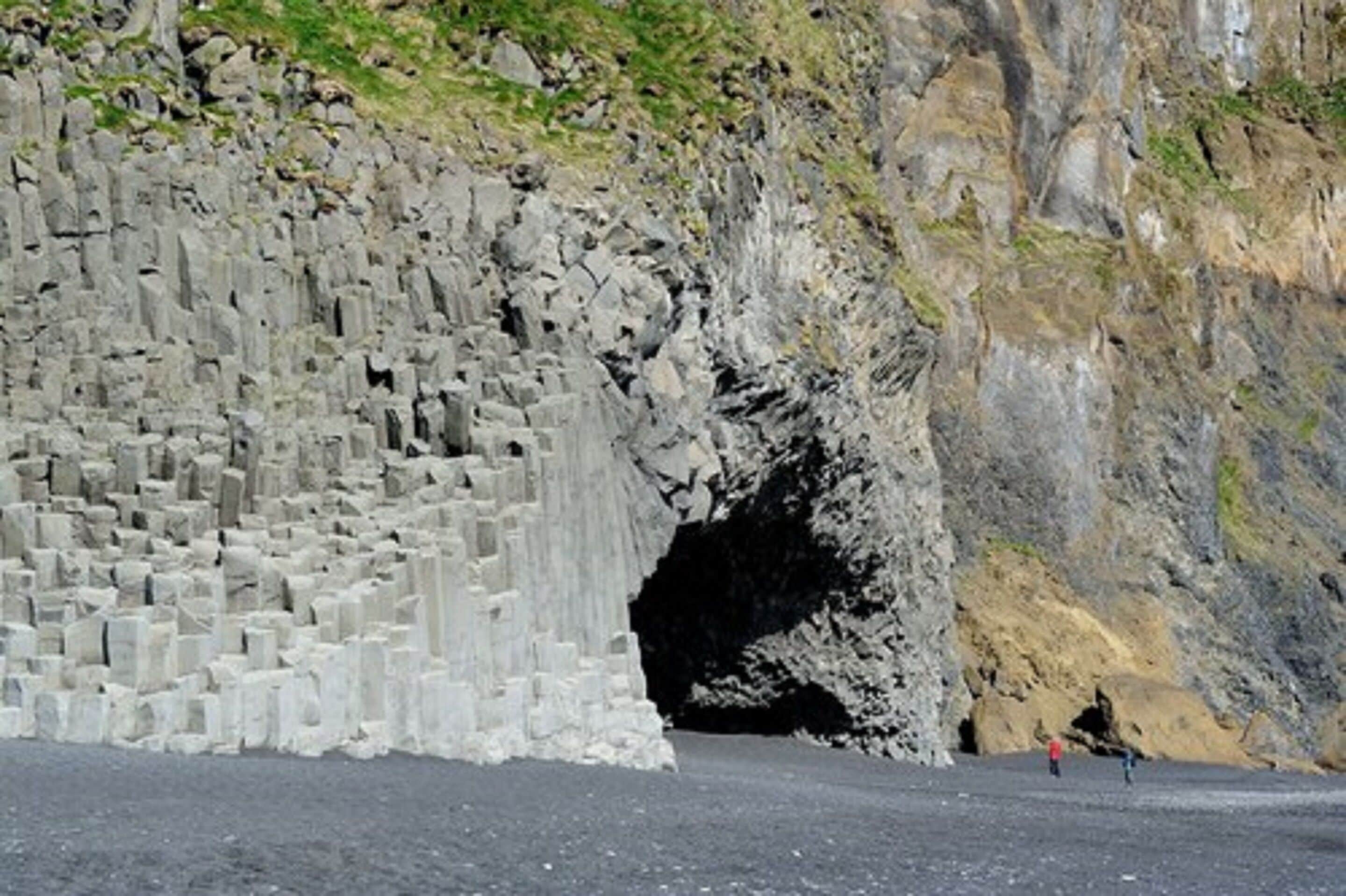 A large, rugged cliff with a cave entrance.