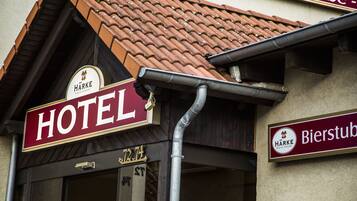 A hotel sign with the name "HARKE" and a beer sign nearby.