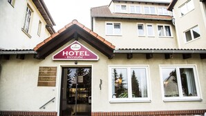A hotel entrance with a sign reading "HOTEL Bierstube" and a sign indicating "Hotel Stadt Pome Restaurant Bierstube." - Hotel Stadt Peine (Peine)