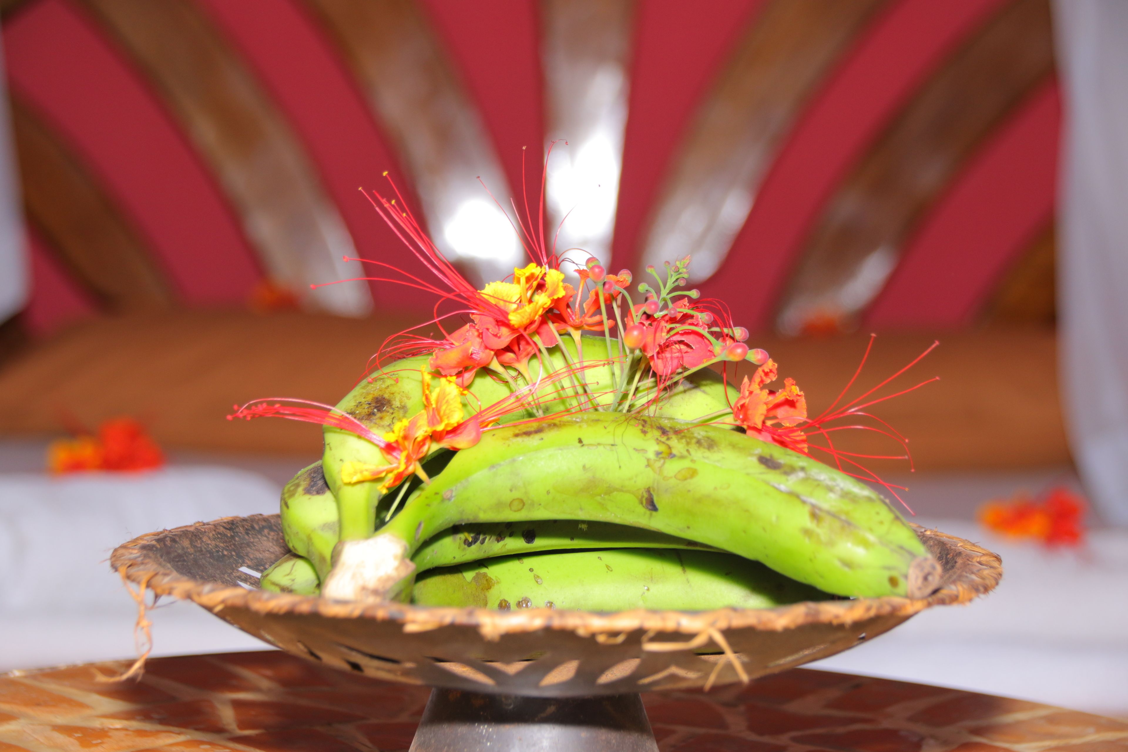Une composition décorative de bananes et de fleurs, présentée sur un présentoir en métal.