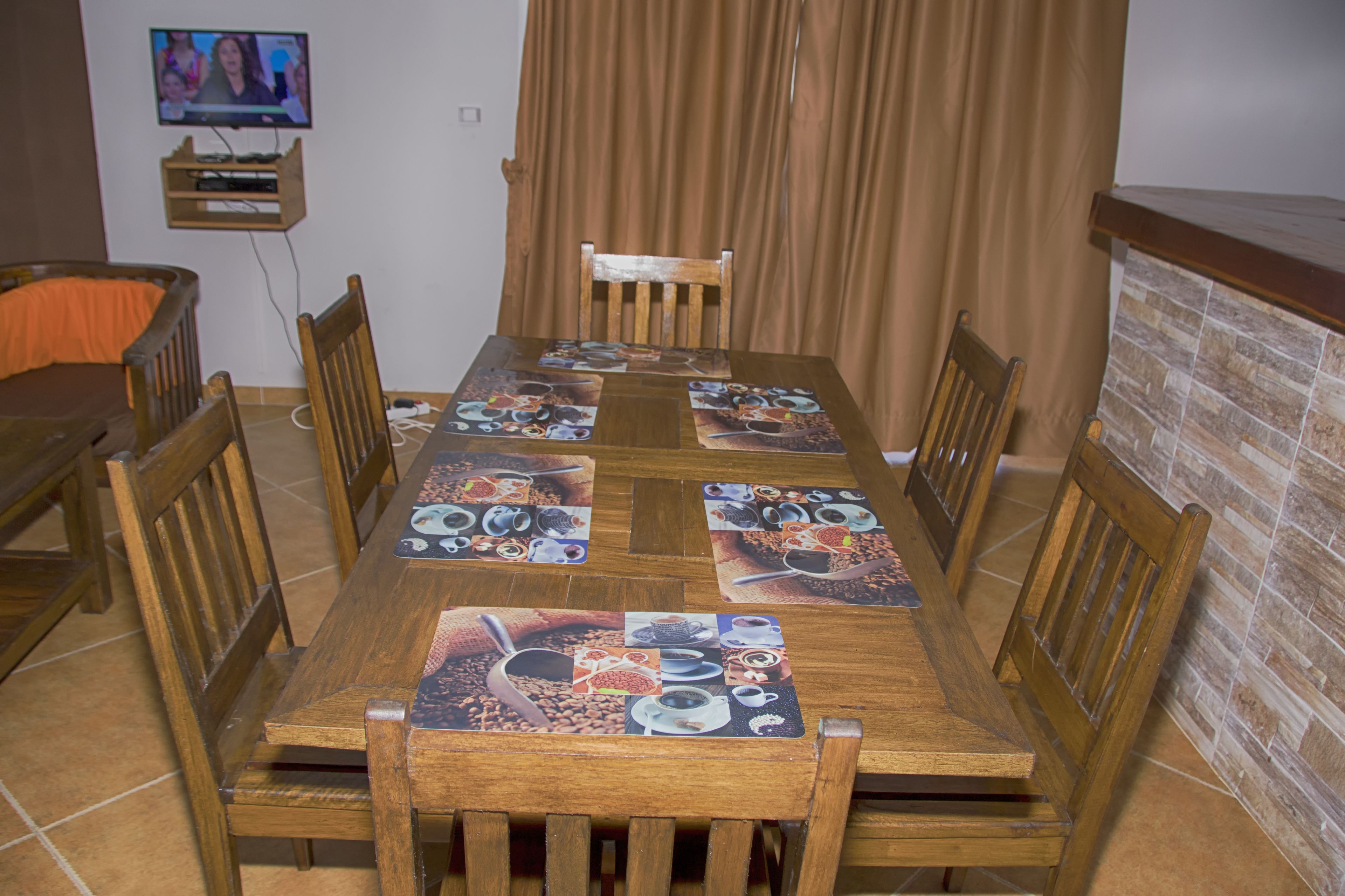 Una mesa de comedor con un televisor montado en la pared superior.