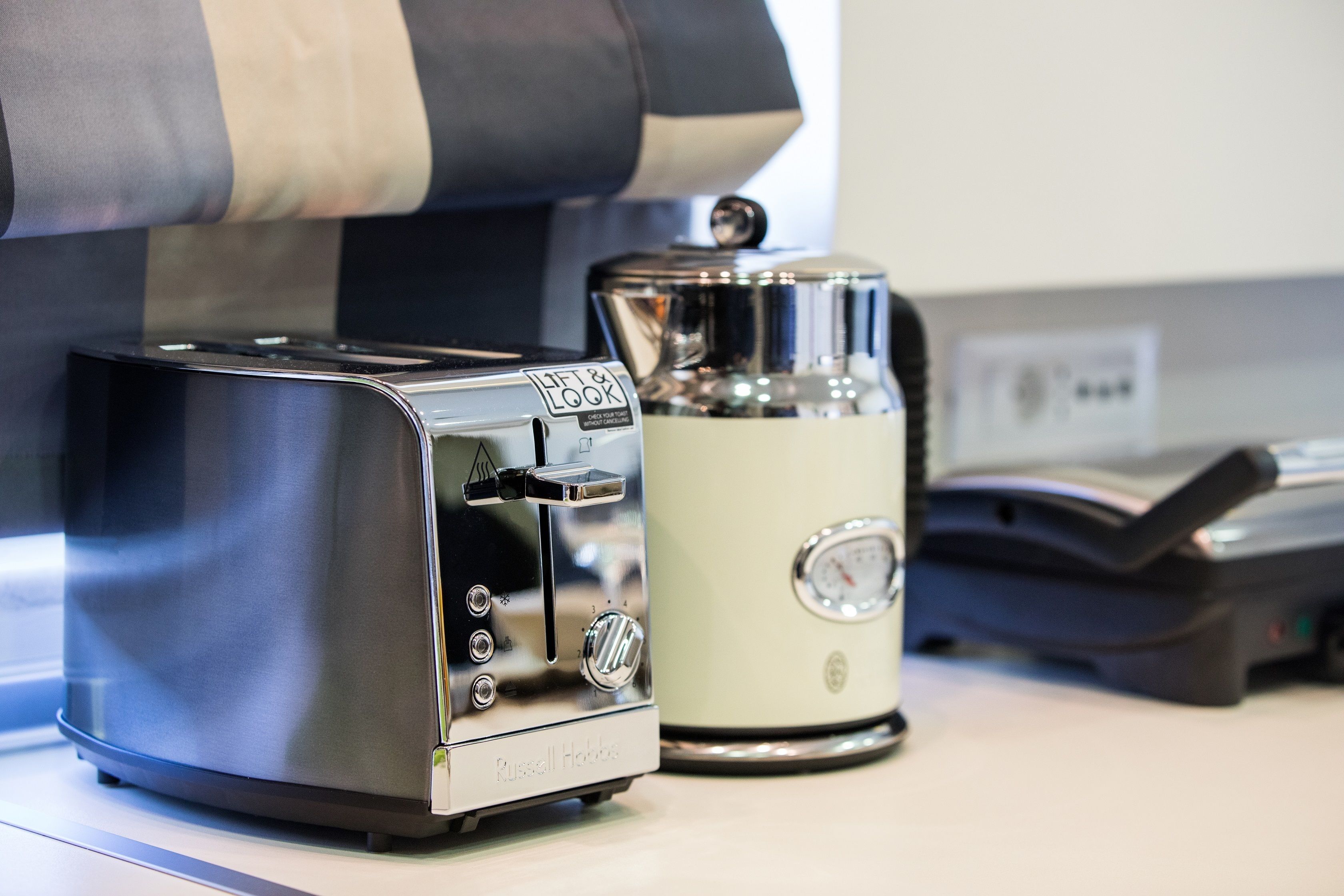 Una cucina con un tostapane e una macchina da caffè sul piano di lavoro.