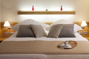 A neatly made bed with a brown bedspread, two bedside lamps, and a tray with a cup and saucer on the bed. - Hotel Drei Morgen (Leinfelden-Echterdingen)