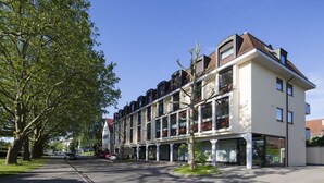 A multi-story hotel with a modern architectural design, featuring large windows and balconies. - Hotel Drei Morgen (Leinfelden-Echterdingen)
