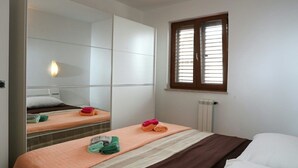 Ein Hotelzimmer mit einem Bett, einem großen Spiegel, einem Fenster mit Jalousien und einer Heizung.