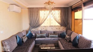 A living room with a sofa set, a coffee table, and a chandelier. - Tamraght House (Aourir)