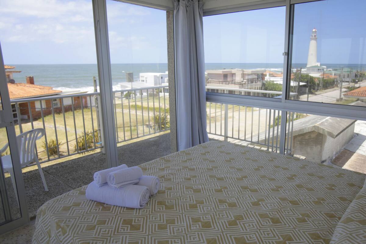 Ein Balkon mit Blick auf das Meer und einen Leuchtturm.