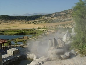 A geothermal area with steam vents, a small pond, and a wooden fence. - Umut Thermal Spa & Wellness Hotel (Saraykoy)