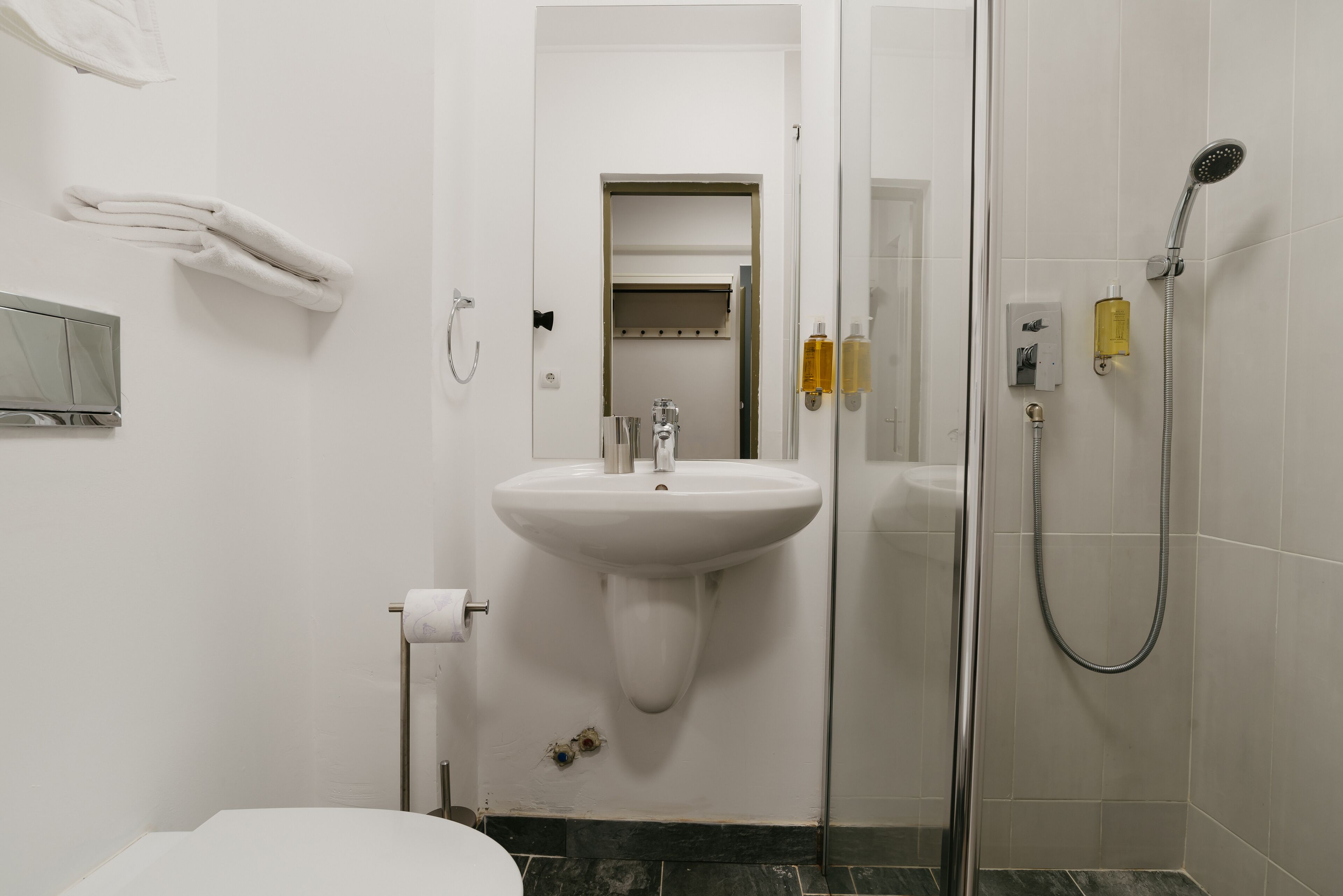 A bathroom with a sink, toilet, and shower.