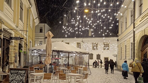 An outdoor café with tables and chairs, surrounded by buildings. - Fullton Central Inn (Cluj-Napoca)