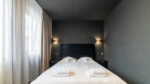 A hotel room with a large bed, two bedside tables, and a dark headboard. - Fullton Central Inn (Cluj-Napoca)