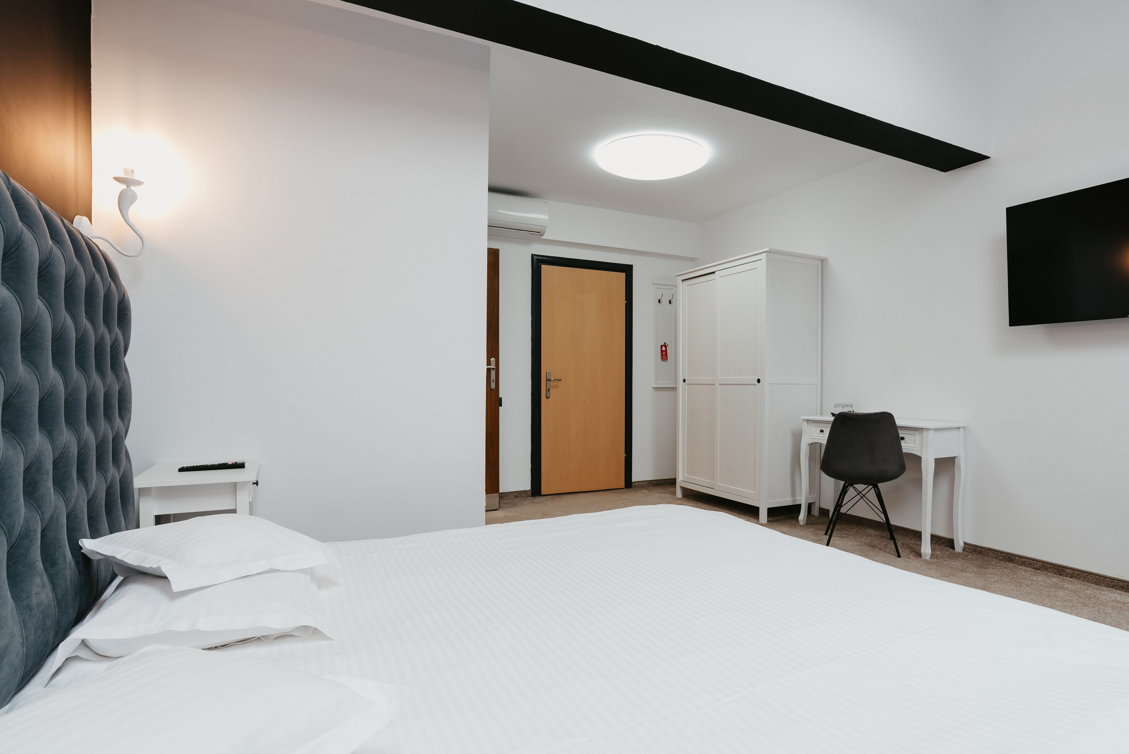 Une chambre d’hôtel équipée d’un lit, d’un bureau, d’une armoire et d’un téléviseur.