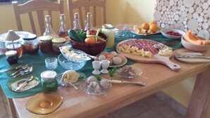 Ein Tisch mit verschiedenen Speisen, darunter Obst, Käse und Würzmitteln.