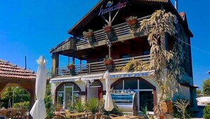 Un edificio a due piani con un balcone, area salotto all'aperto e piscina.