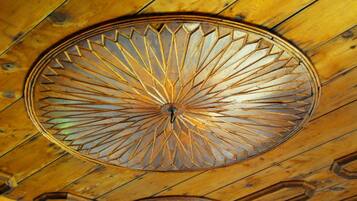 A wooden ceiling with a circular, geometric-patterned design.