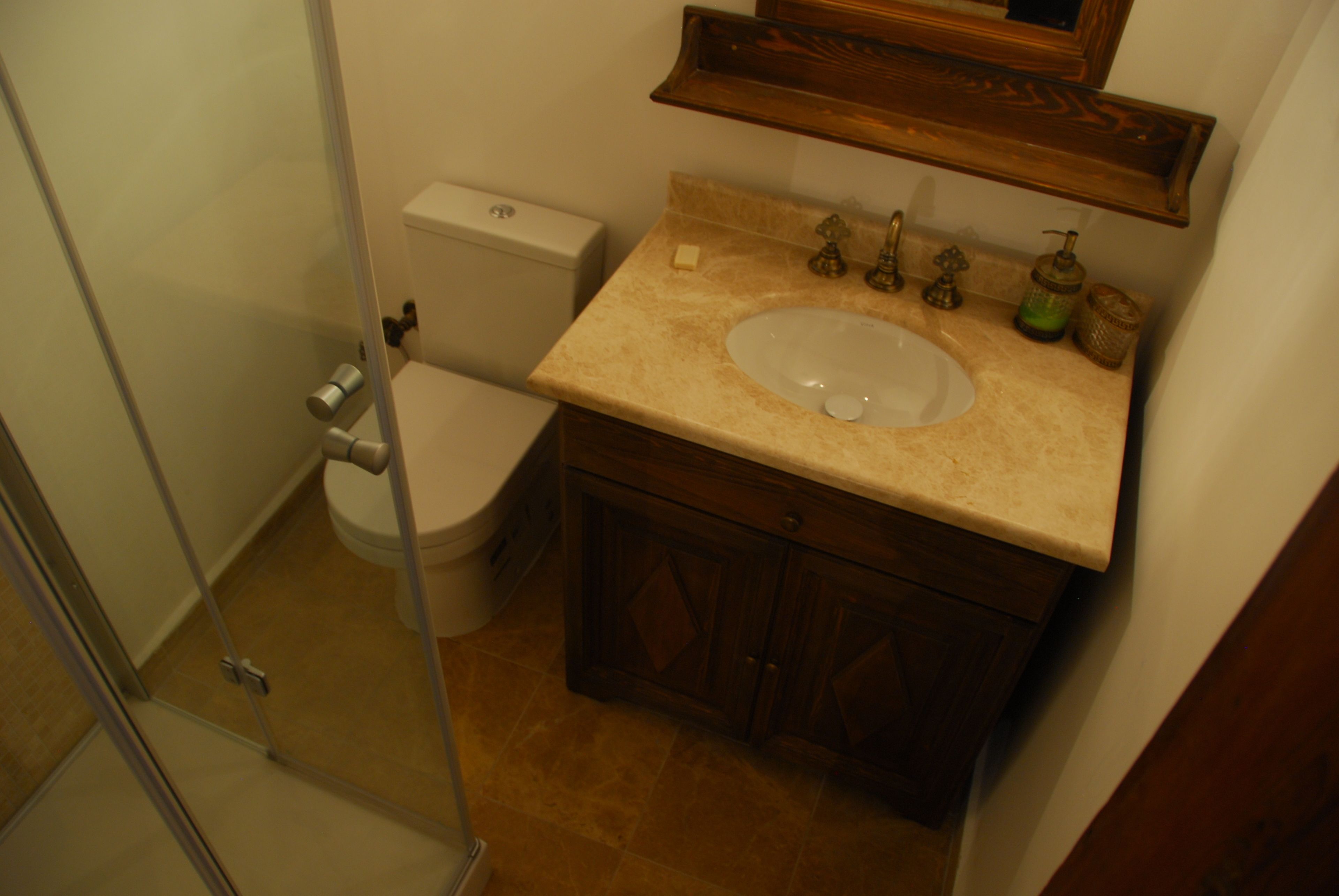 A bathroom with a toilet, sink, and shower.