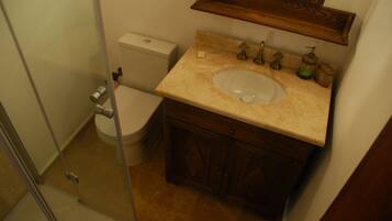 A bathroom with a toilet, sink, and shower.