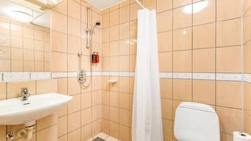 A small bathroom with a shower, toilet, and sink.
