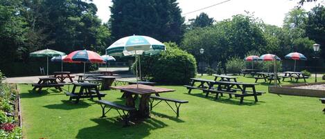 An outdoor seating area with picnic tables and umbrellas.