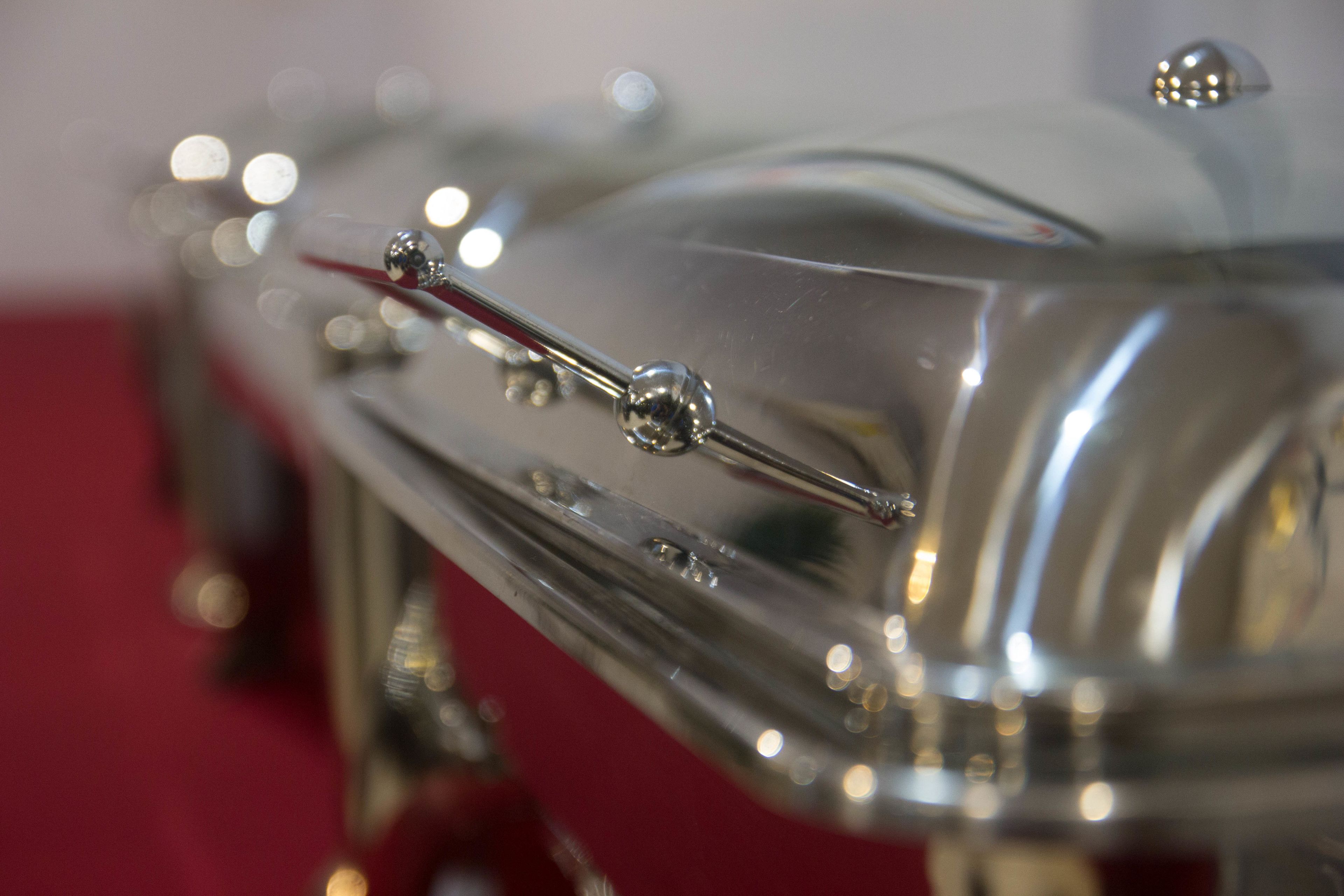 A close-up of a shiny, metallic object with reflective surfaces and small spherical details.