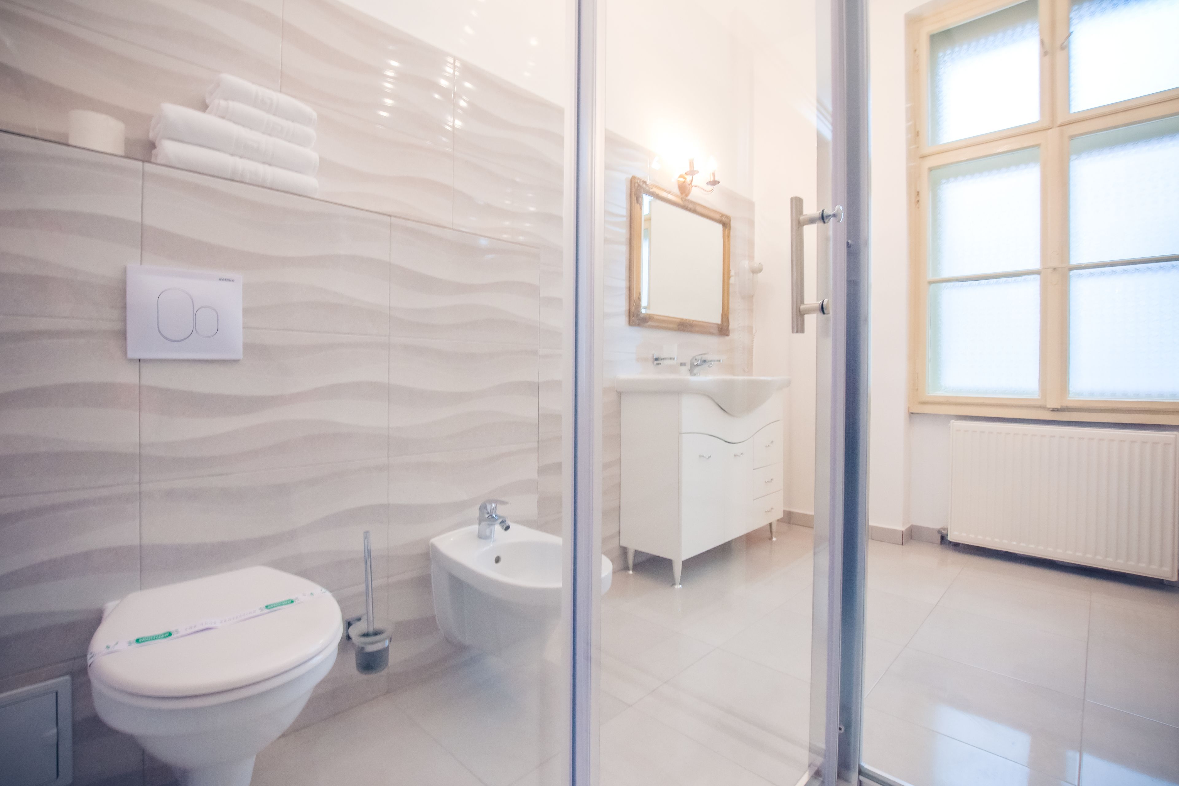 A modern bathroom with a toilet, bidet, and vanity.