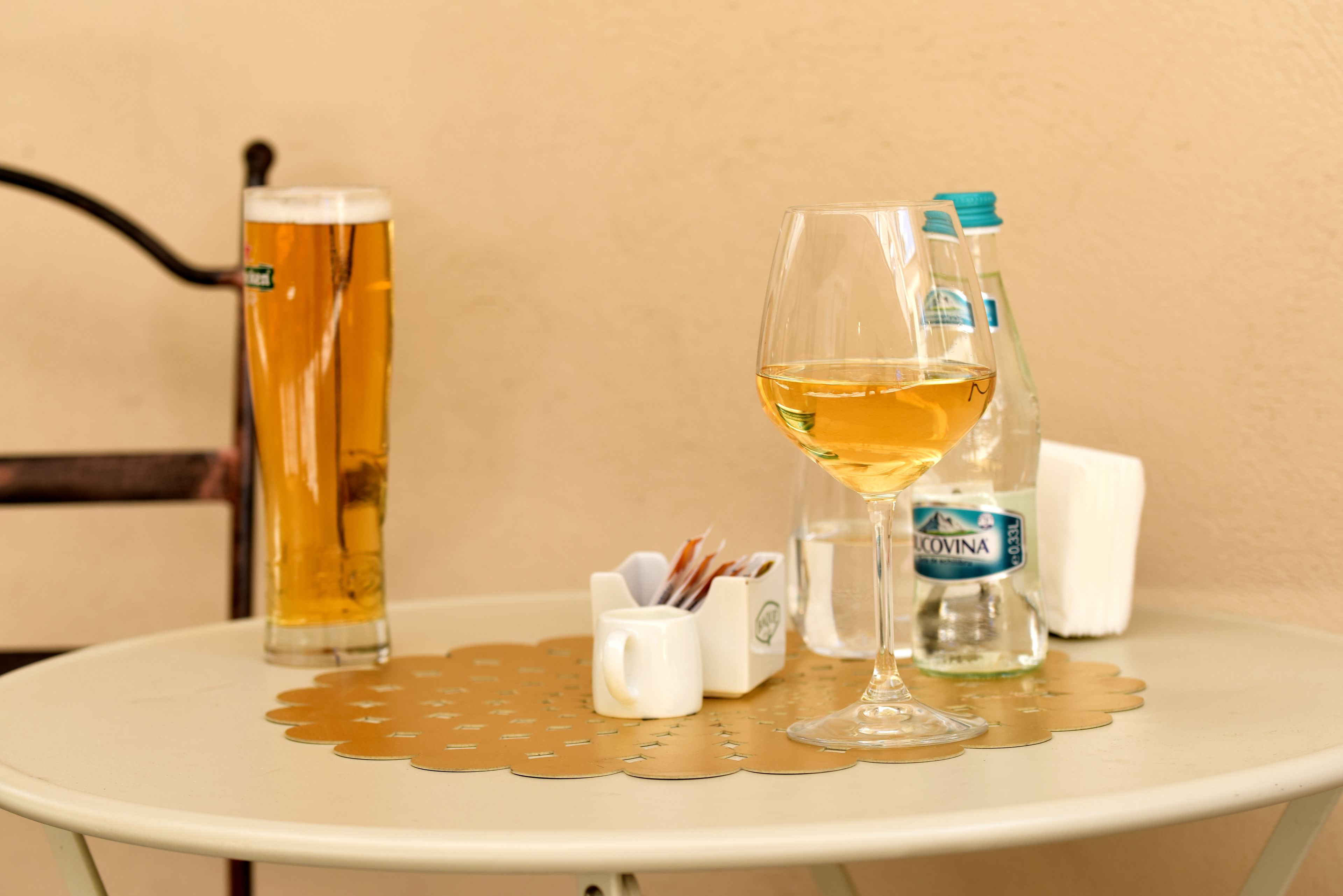 A table with a beer mug, a wine glass, and a bottle of water.