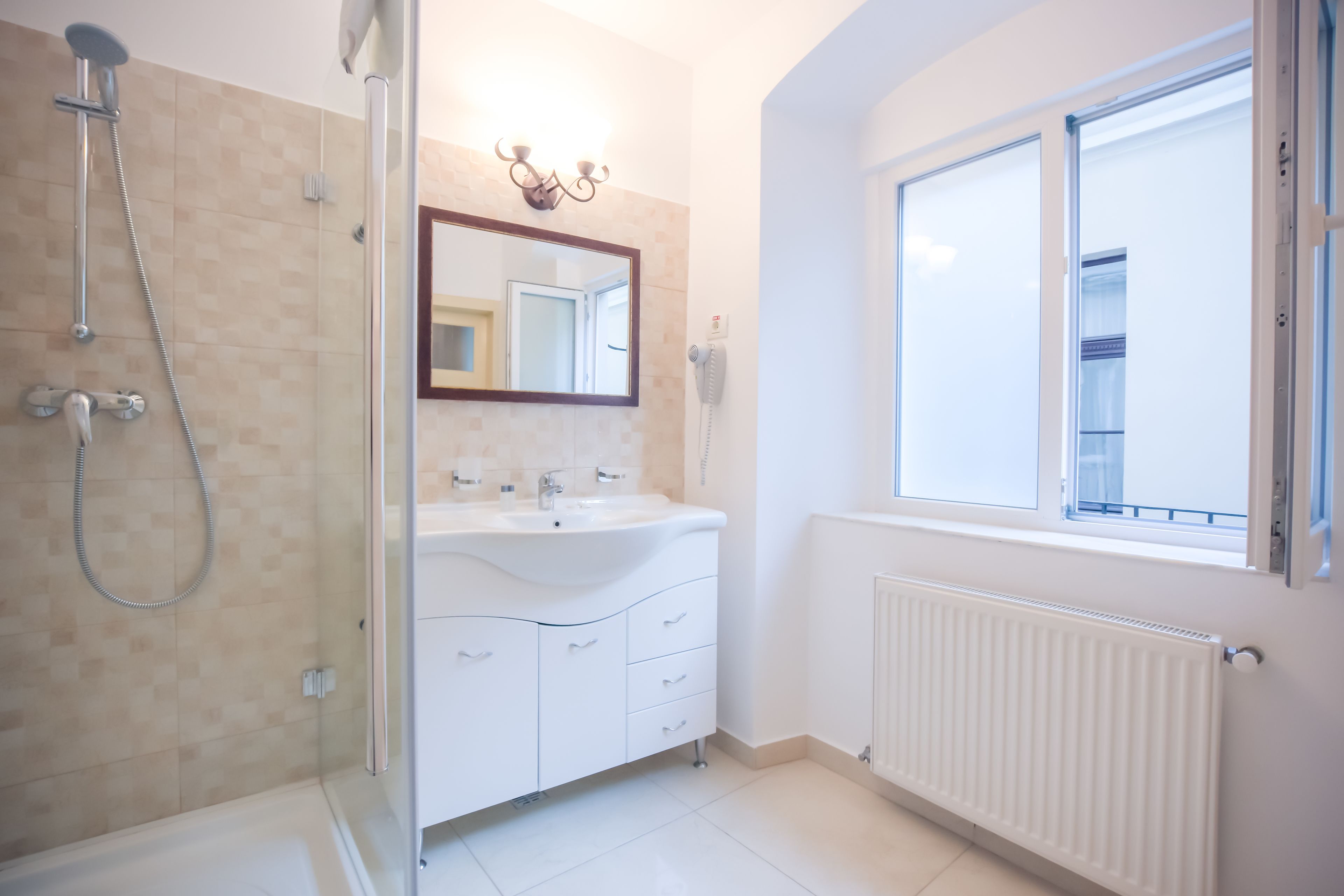 A modern bathroom with a shower, a sink, and a mirror.