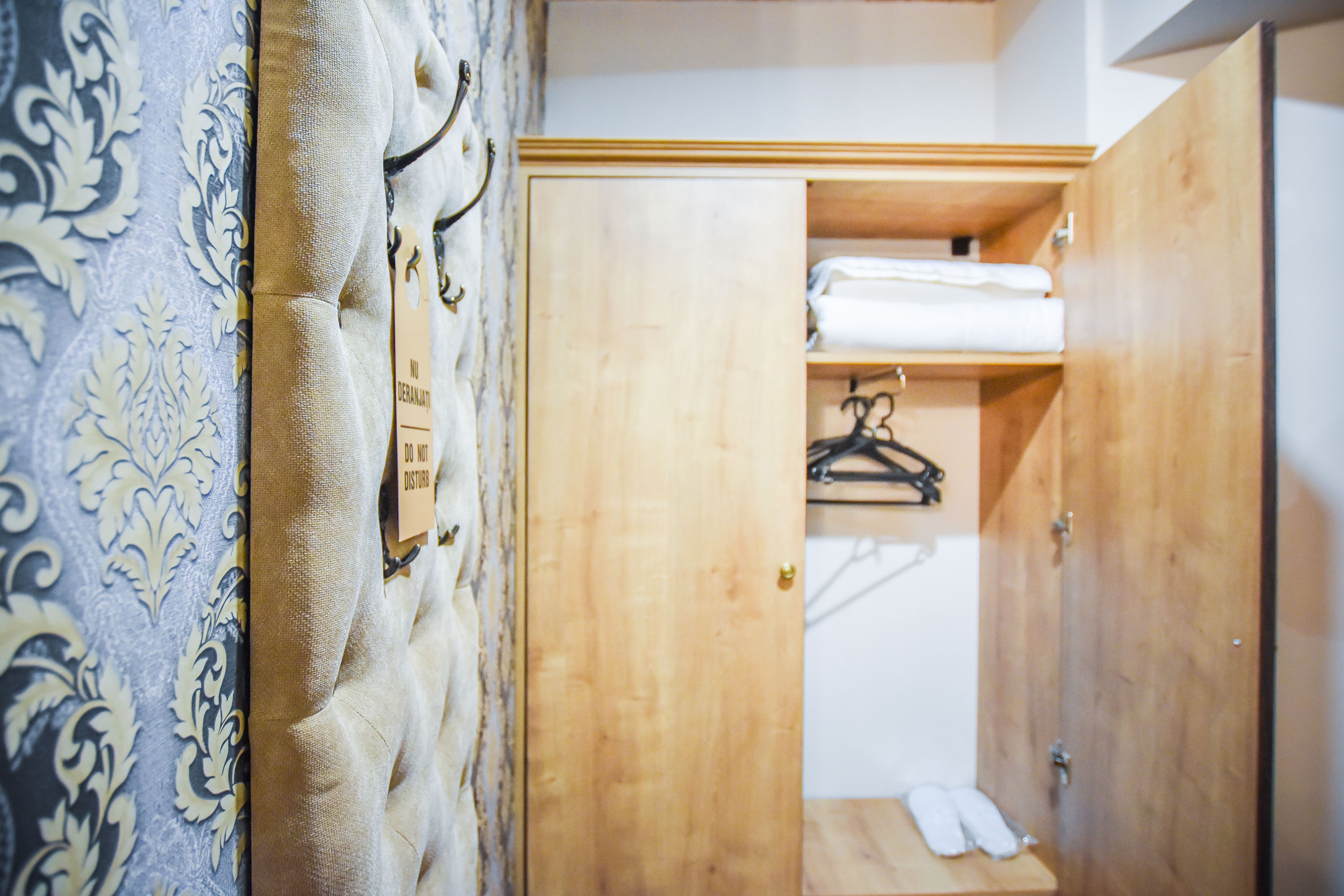 Ein Holzkleiderschrank mit Kleiderstange und Ablagefläche.