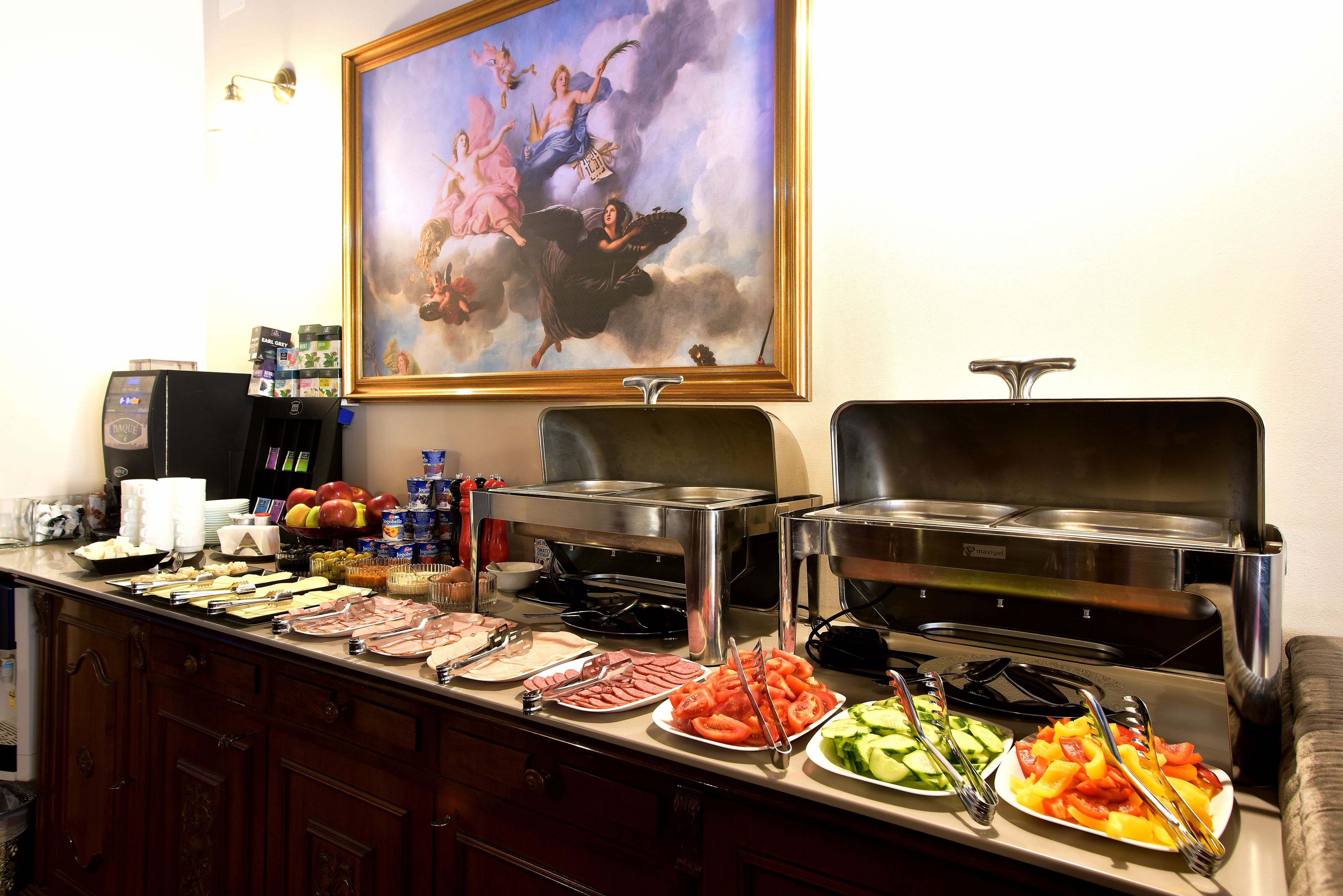Un buffet con diversi cibi e un dipinto di putti sulla parete.
