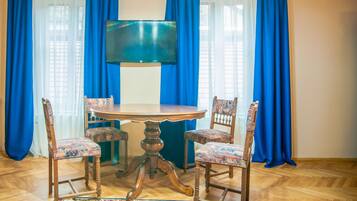 Un comedor con una mesa redonda, cuatro sillas y un televisor.