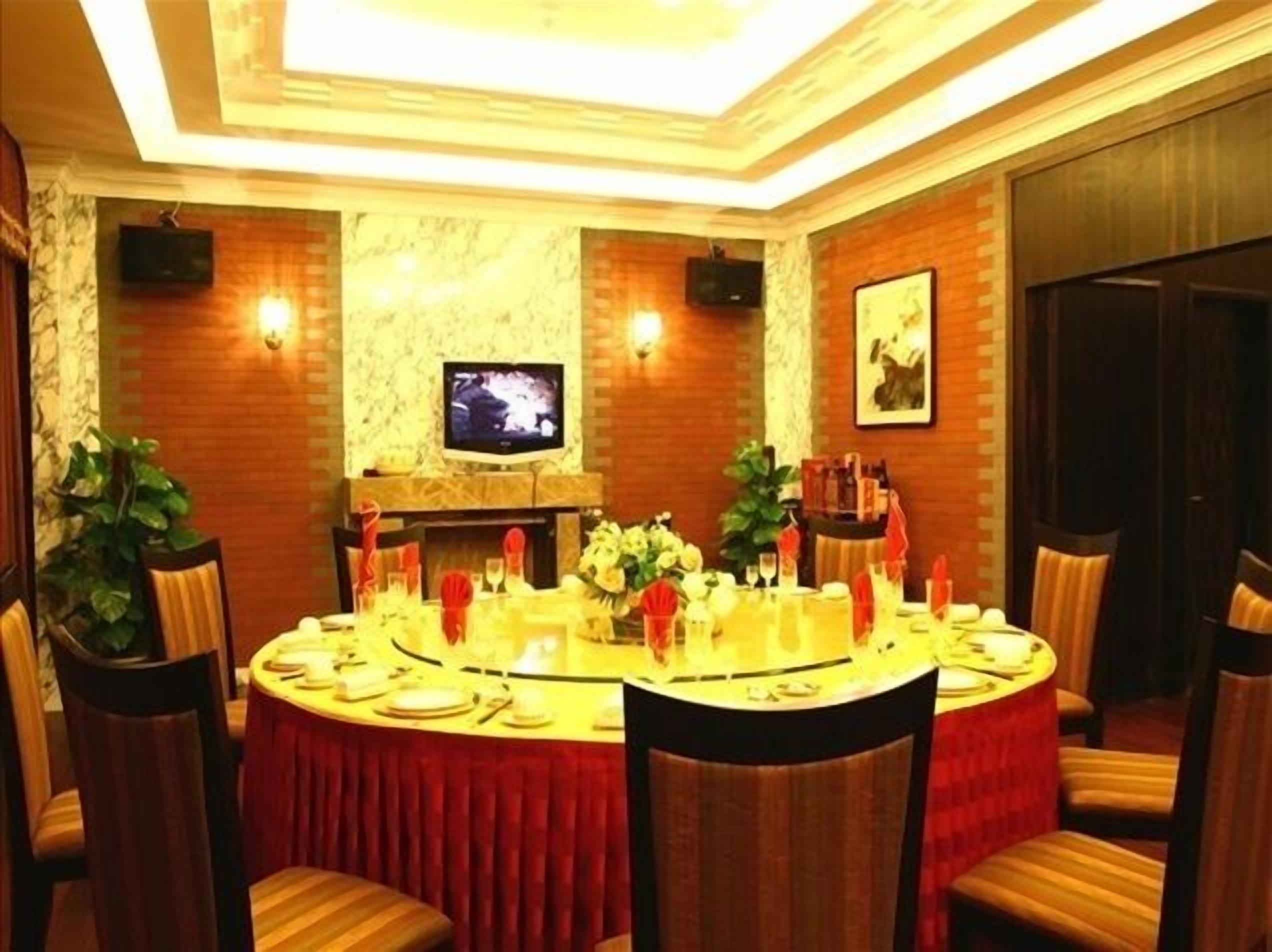A conference room with a round table, chairs, a TV, and a fireplace.