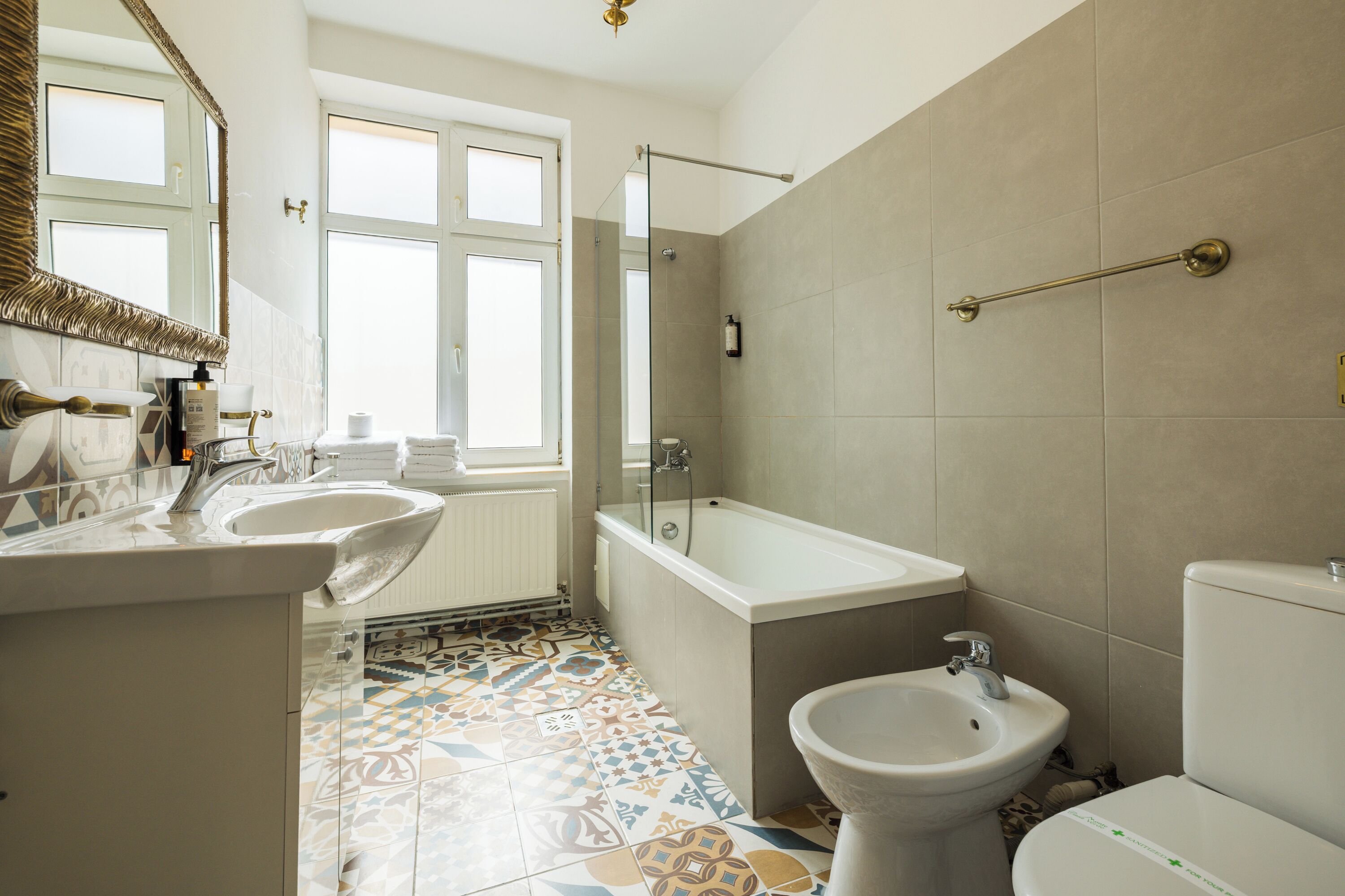 A bathroom with a bathtub, a sink, a bidet, and a toilet.
