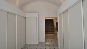 A narrow hallway with a tiled floor and a staircase at the end. - Relais Virginia Home (Sanremo)