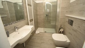 A modern bathroom with a glass-enclosed shower, a white sink, and a toilet. - Relais Virginia Home (Sanremo)