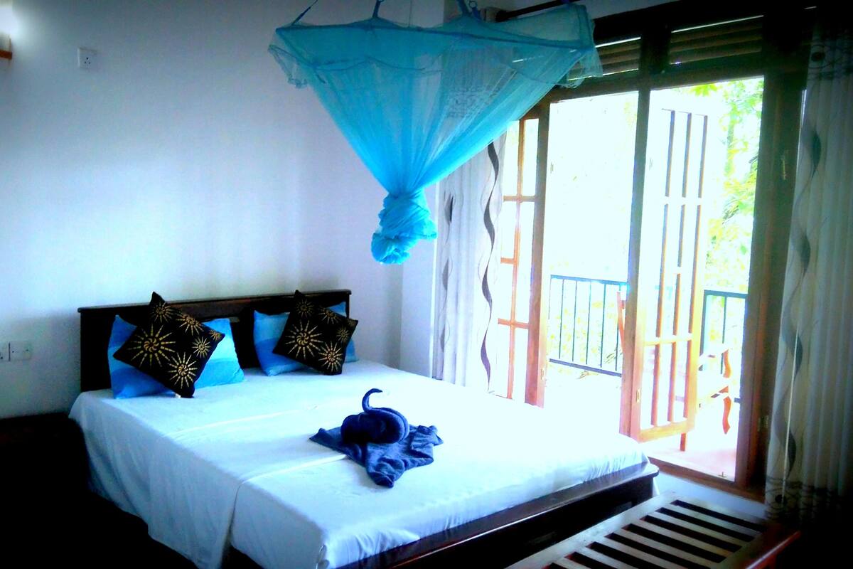 Un dormitorio con cama, mosquitera y vistas al exterior.