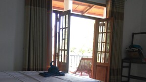 Een kamer met twee bedden, een houten stoel en een tafel.