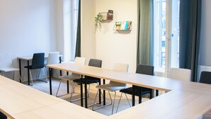 A conference room with a long table, chairs, and a window with curtains. - Hotel Actuel Chambéry Centre (Chambery)
