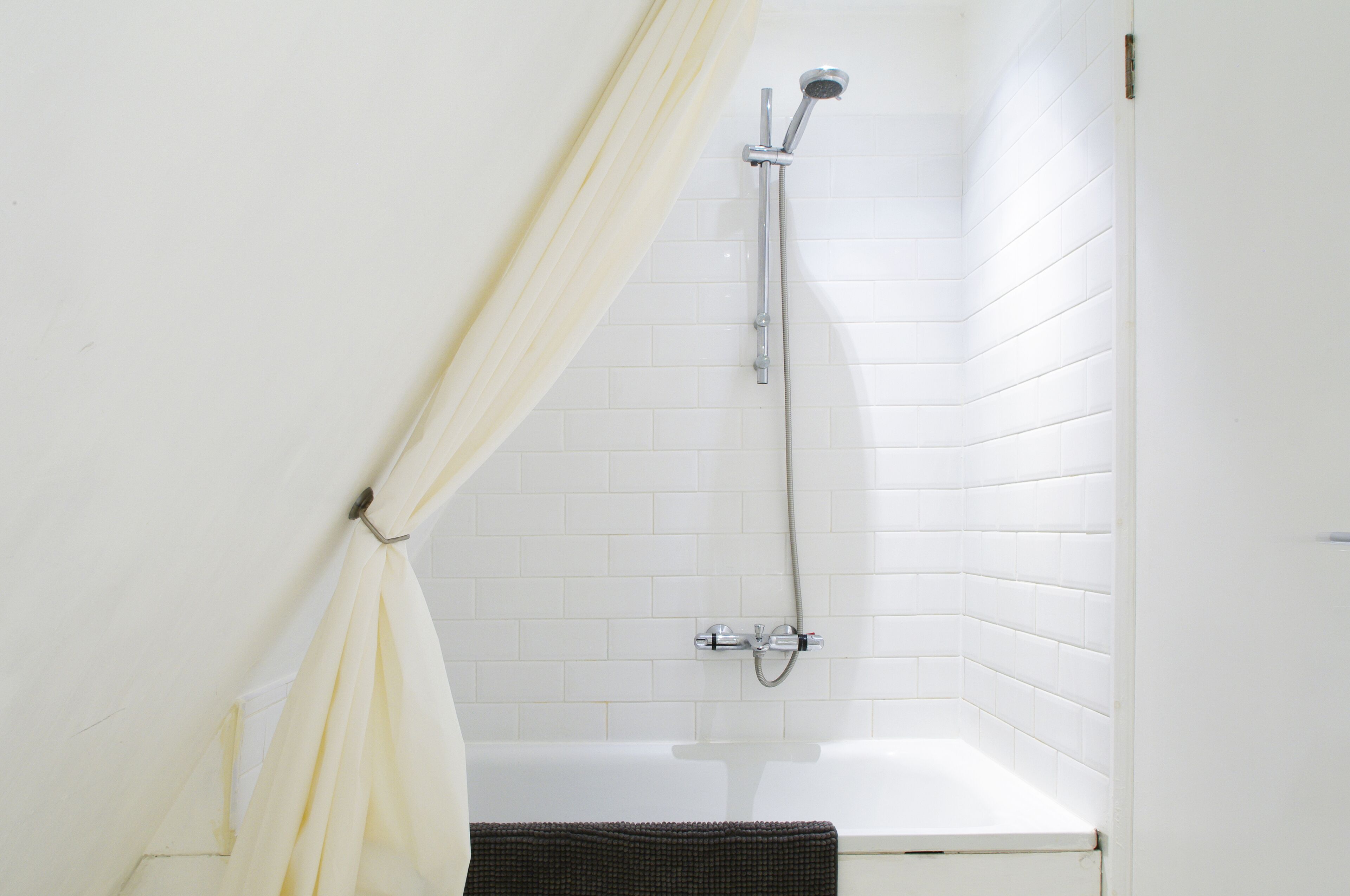 A bathroom with a shower, a bathtub, and a curtain.