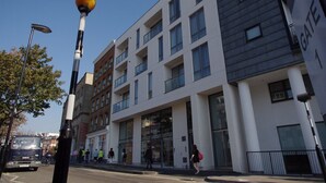 A multi-story building with a modern architectural design, featuring large windows and a prominent entrance. - The London Agent Clerkenwell Super Nice (London)