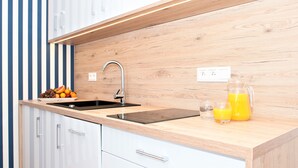 Eine moderne Küche mit Holzarbeitsplatte, Edelstahlspüle und Obstschale.