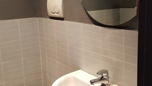 A bathroom with a toilet, sink, and mirror. - Verona4rent Giulia (Verona)