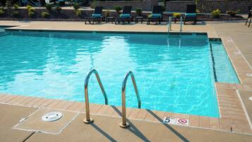 A swimming pool with clear blue water, a no diving sign, and a 5 ft depth marker.