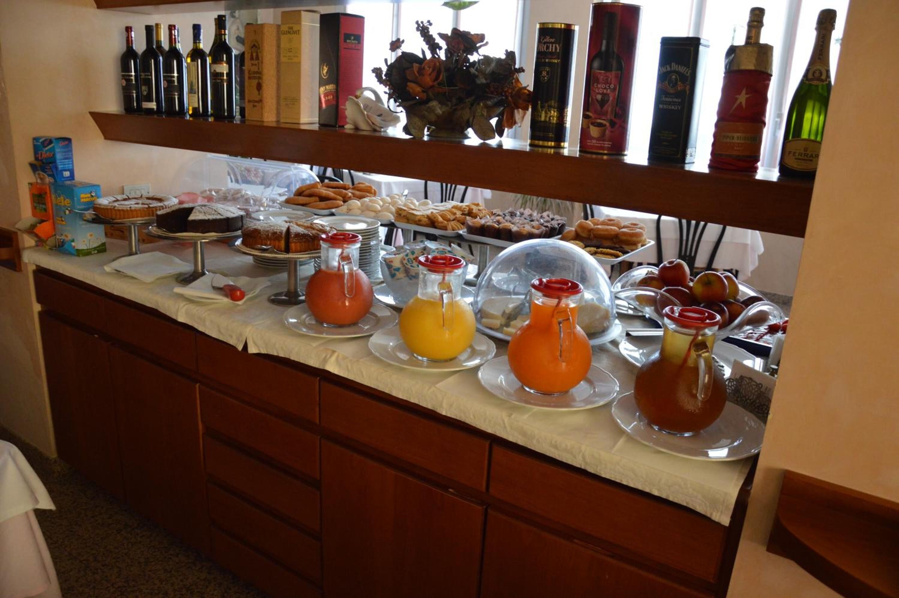 A buffet with various food items, drinks, and bottles of alcohol.