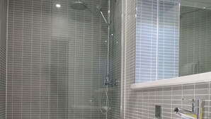 A modern bathroom with a glass-enclosed shower, a white toilet, and a sink with a wooden vanity. - The London Agent Fitzrovia Studio 1 (London)