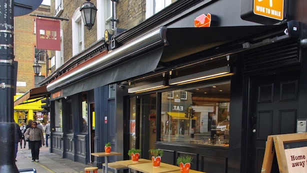 A street-side café with outdoor seating, a "Work to Walk" sign, and a chalkboard menu board. - The London Agent Fitzrovia Studio 2 (London)