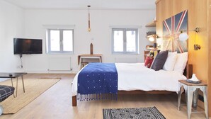 A bedroom with a bed, a television, and a wooden wardrobe. - The London Agent Fitzrovia Studio 3 (London)